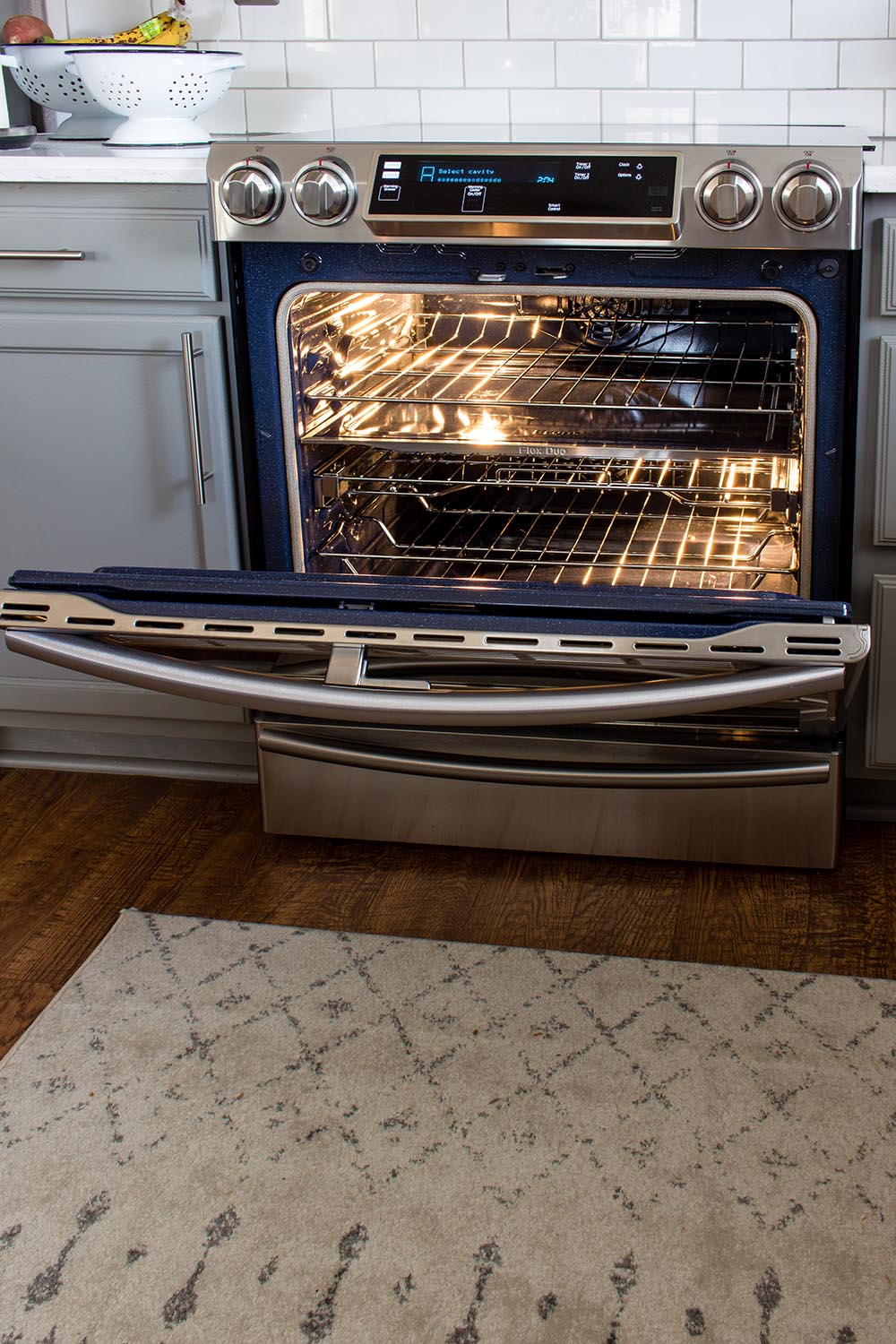 Three cooking racks are exposed through the open door of a Samsung double oven.