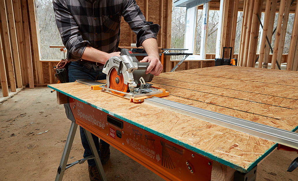 A circular saw being used to cut a straight line.