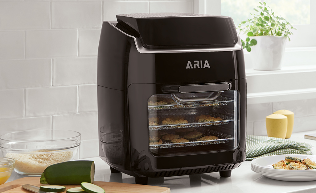 A black dehydrator on a kitchen counter in front of a window.