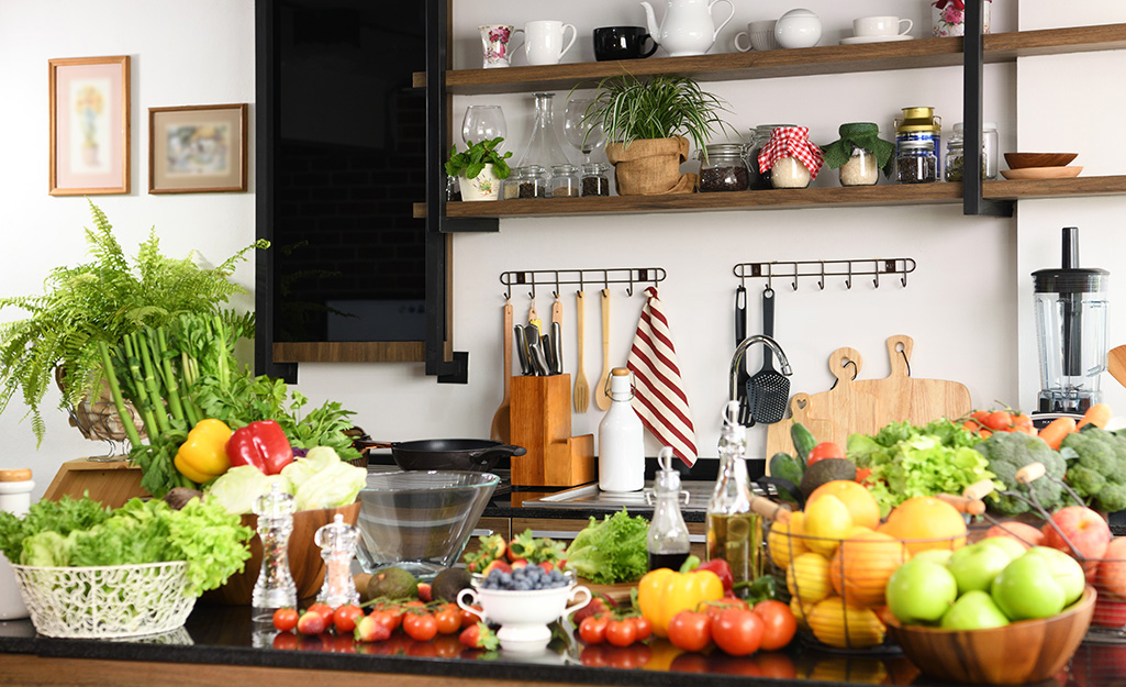 An abundance of fresh produce sits on a kitchen counter. 