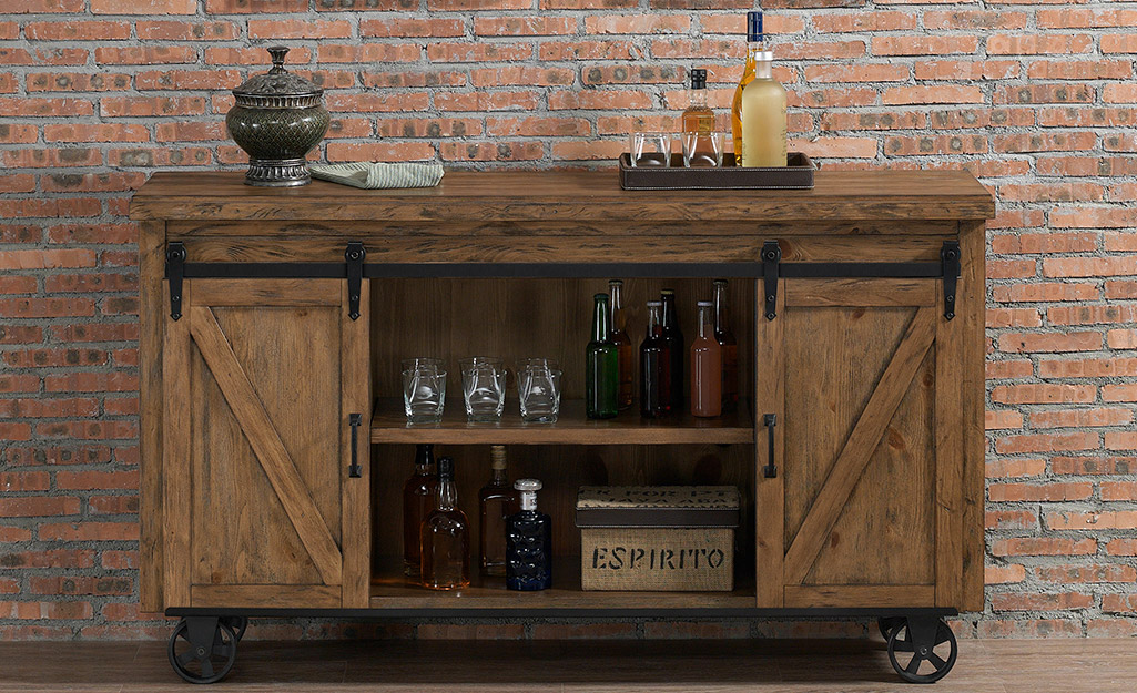 A rustic industrial bar cart with sliding barn doors.