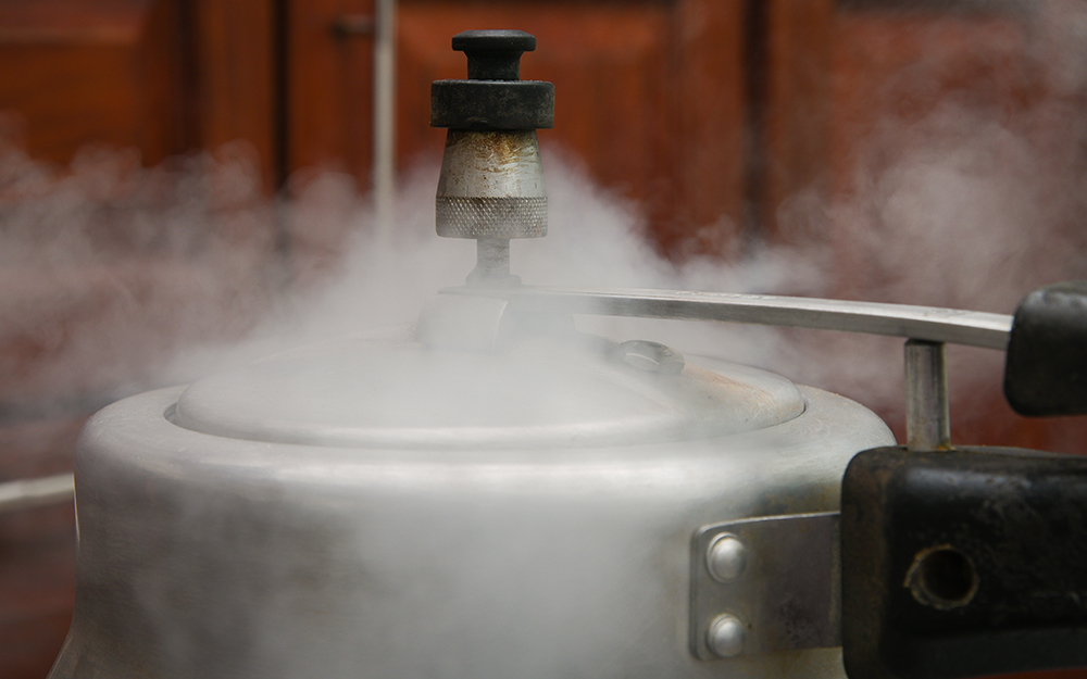 A steam escapes from a "jiggle top" pressure cooker.