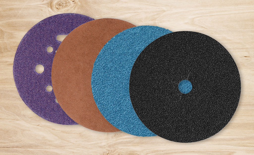 Four circular pieces of sandpaper in four sizes lay in an overlapping row. 