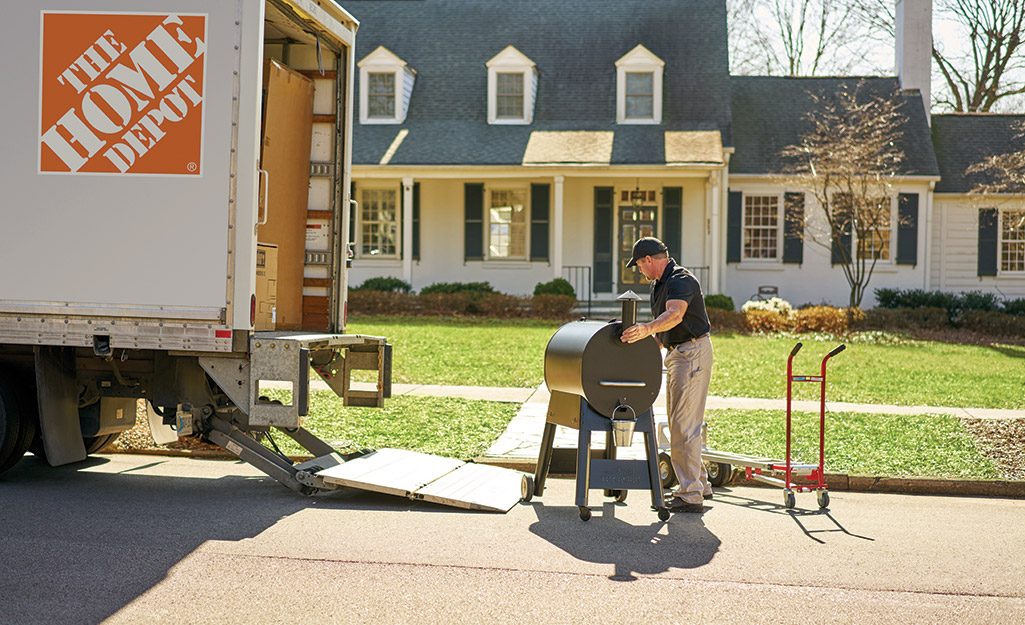 A Home Depot associate dropping off a package to a homeowner.