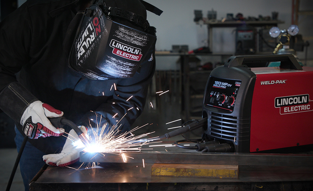 A person welding metal. A person welding metal.