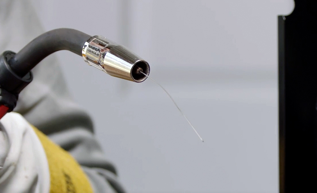A welding torch nozzle with extended wire. 