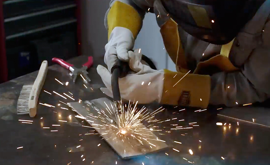 A person applies welding to a section of stainless steel. 