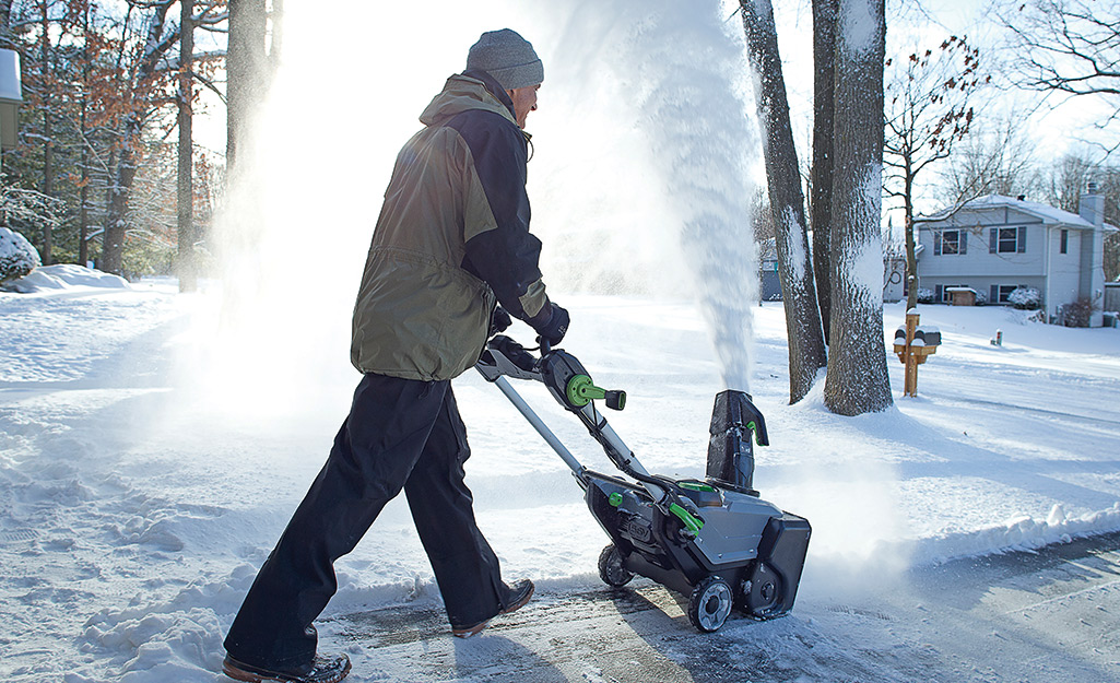 Person using a snow blower to remove snow.