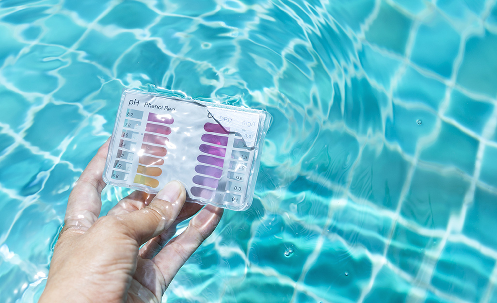 A person using a test kit in a pool.