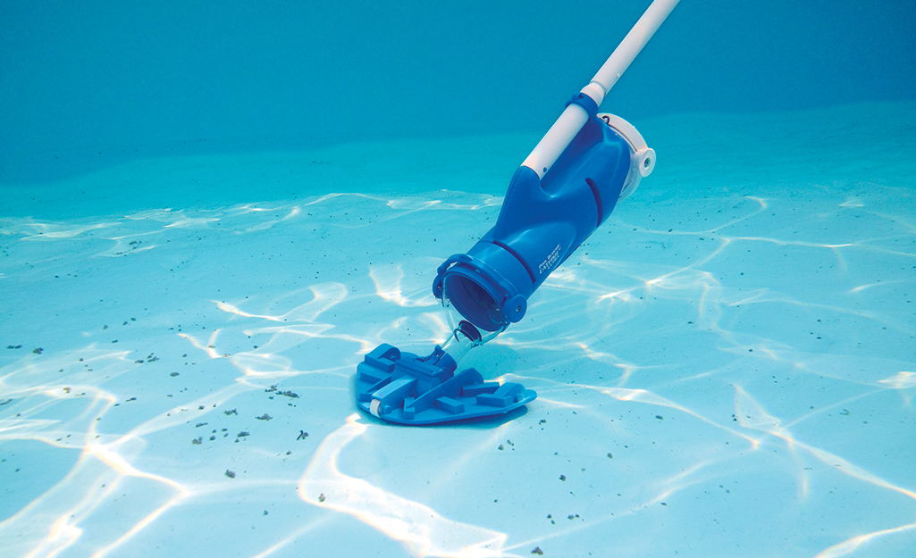 A pool vacuum being used on a pool floor.