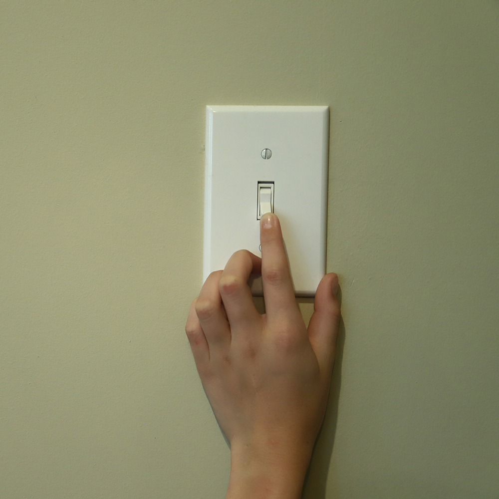 A hand and a light switch.