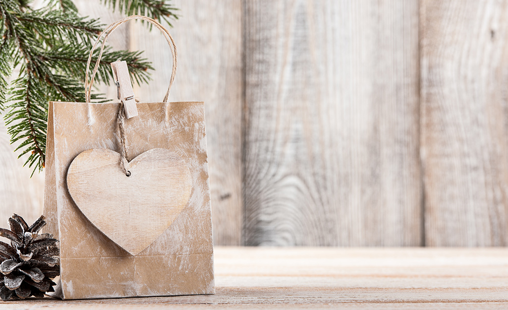 A brown gift bag with a paper heart tied to the bag handle.