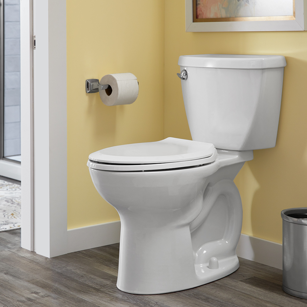 A picture of a clean bathroom with a white toilet and bright yellow walls.