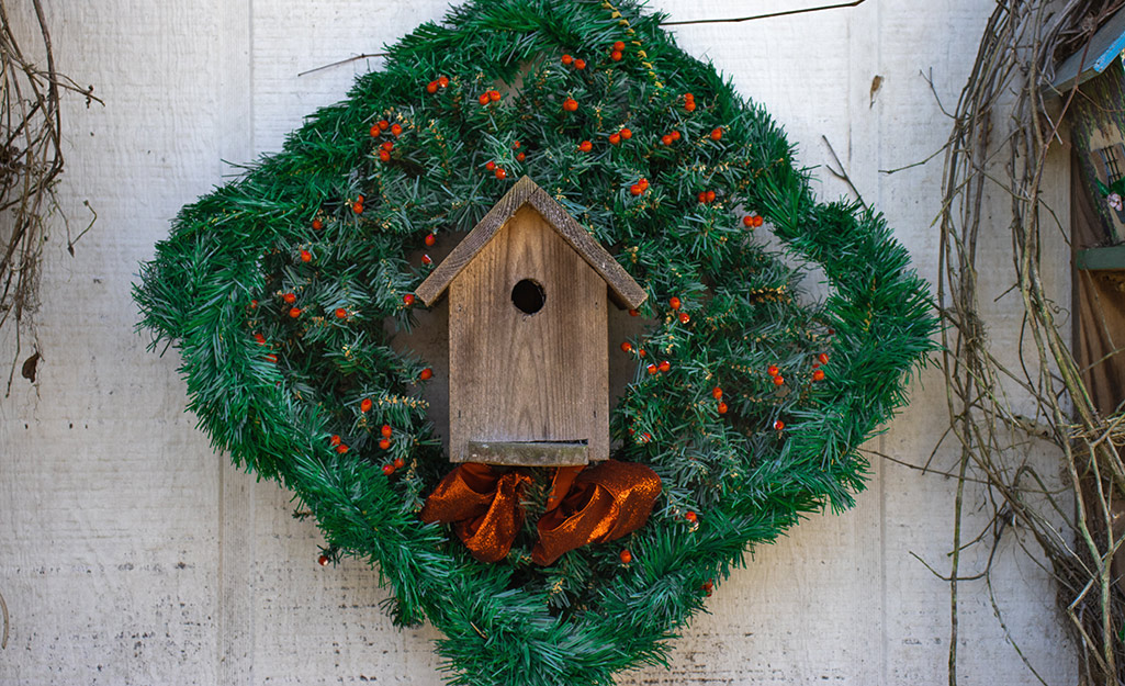 A birdhouse wreath hanging up.