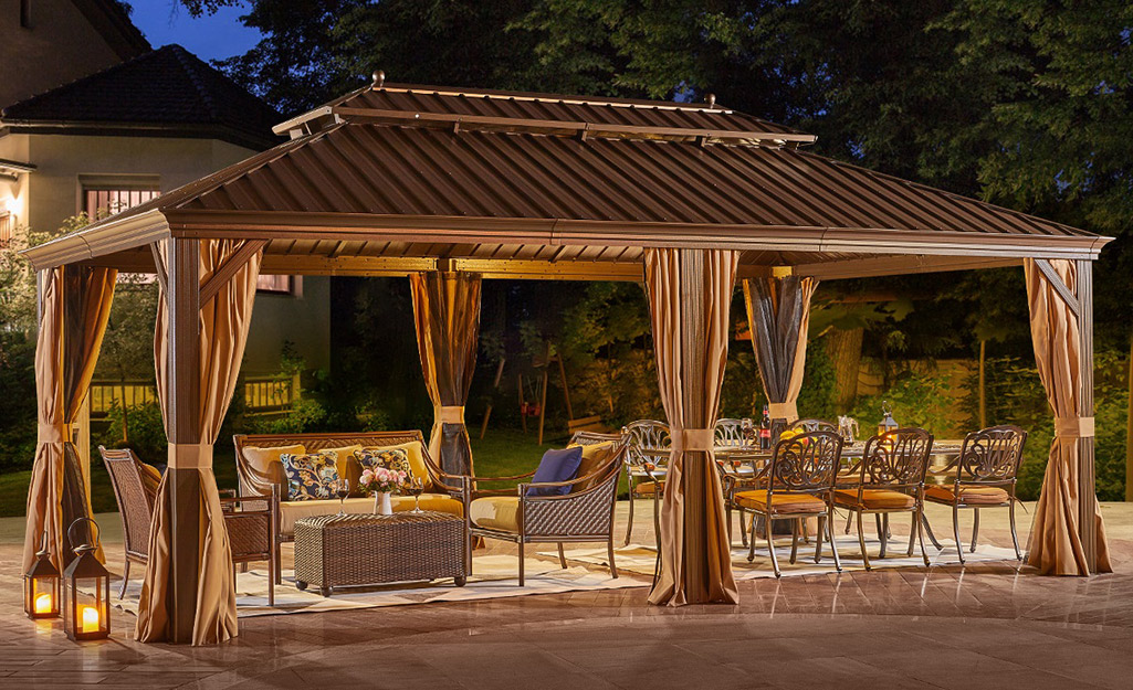 A large pergola covers an outdoor living room and an outdoor dining space.