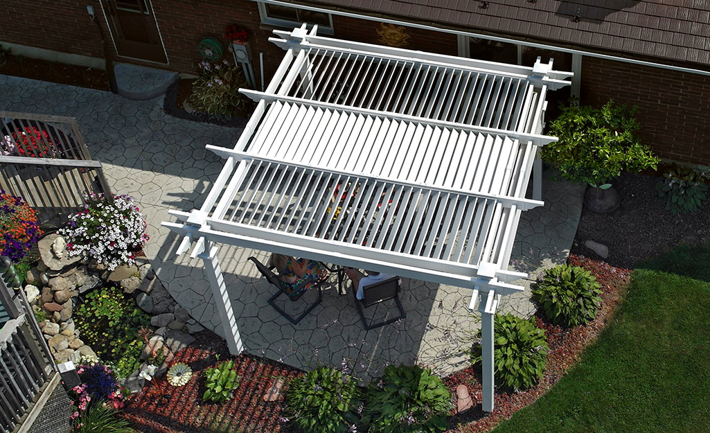 A pergola over chairs on a patio can be seen from above.