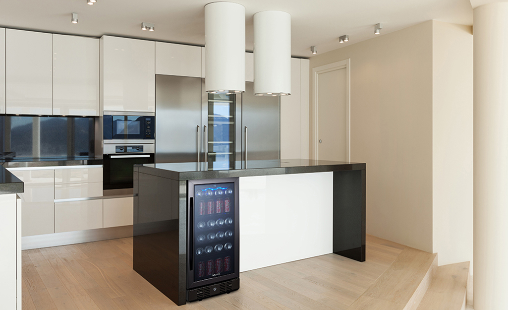 A black kitchen island with a cooler integrated into it.