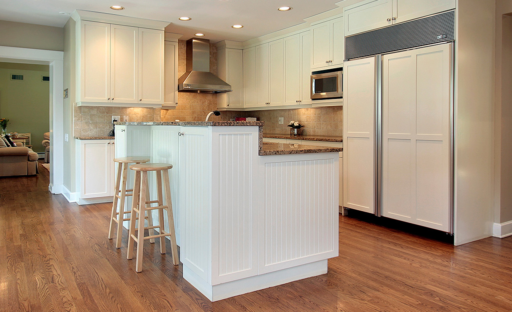 A white two-level kitchen island with two stools.