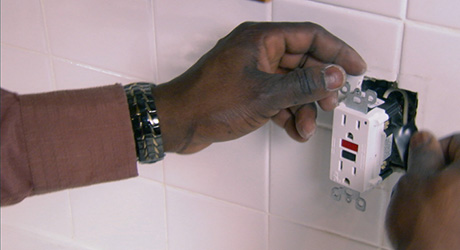 A person removes the old power outlet. A person removes the old power outlet.