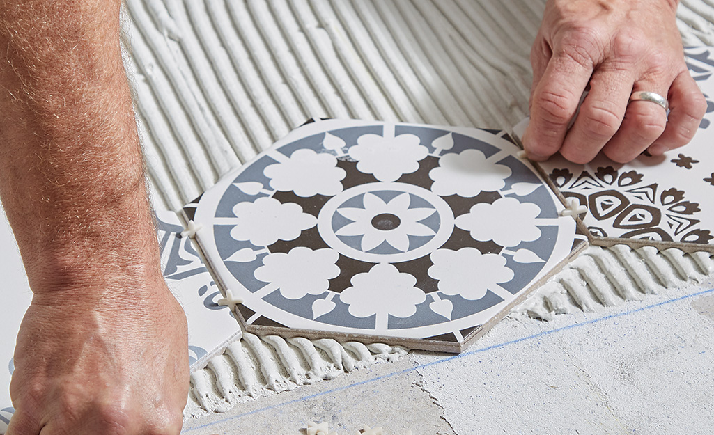 Man adding spacers between round tiles.