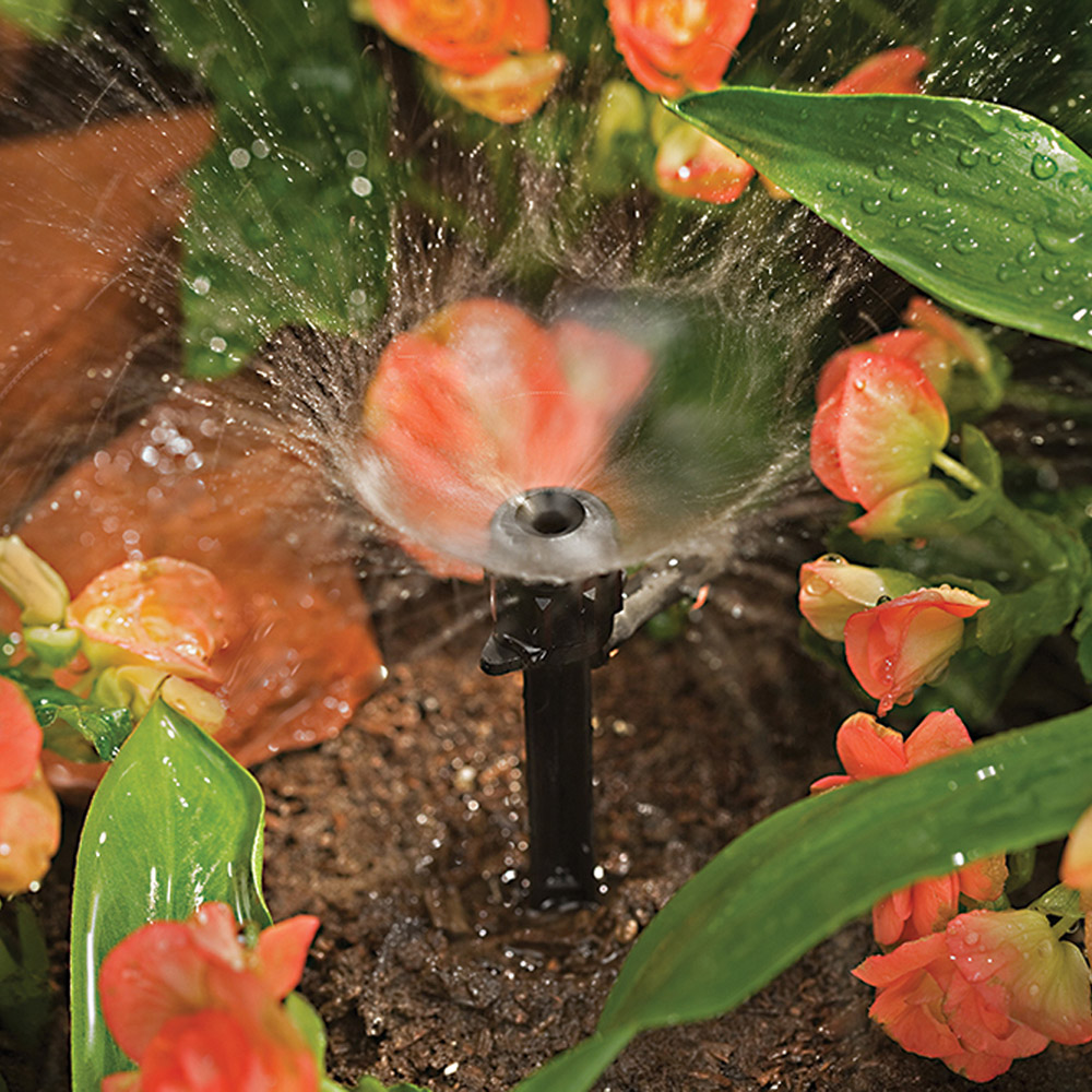 A sprinkler watering flowers. 