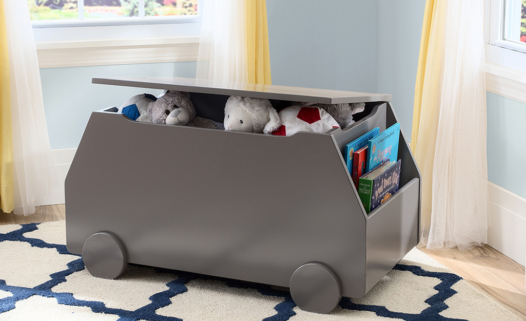 A grey storage crate for toys and books. A grey storage crate for toys and books.