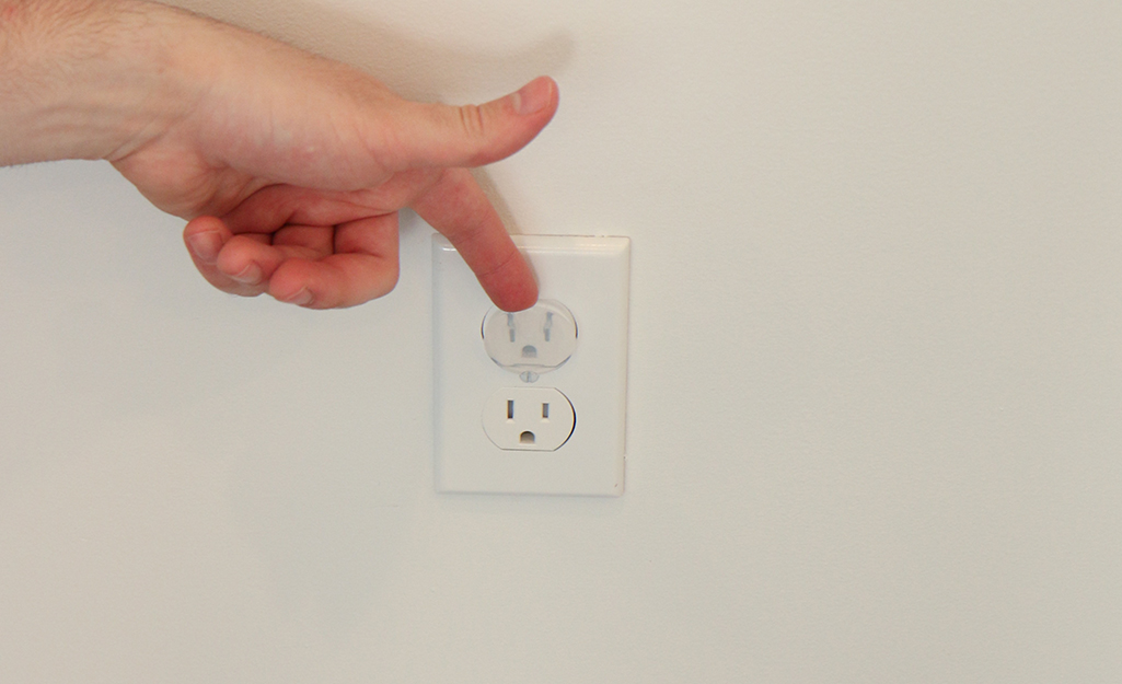 A person installing outlet covers. A person installing outlet covers.