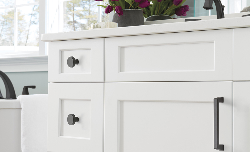 White cabinets with both knobs and pulls installed.