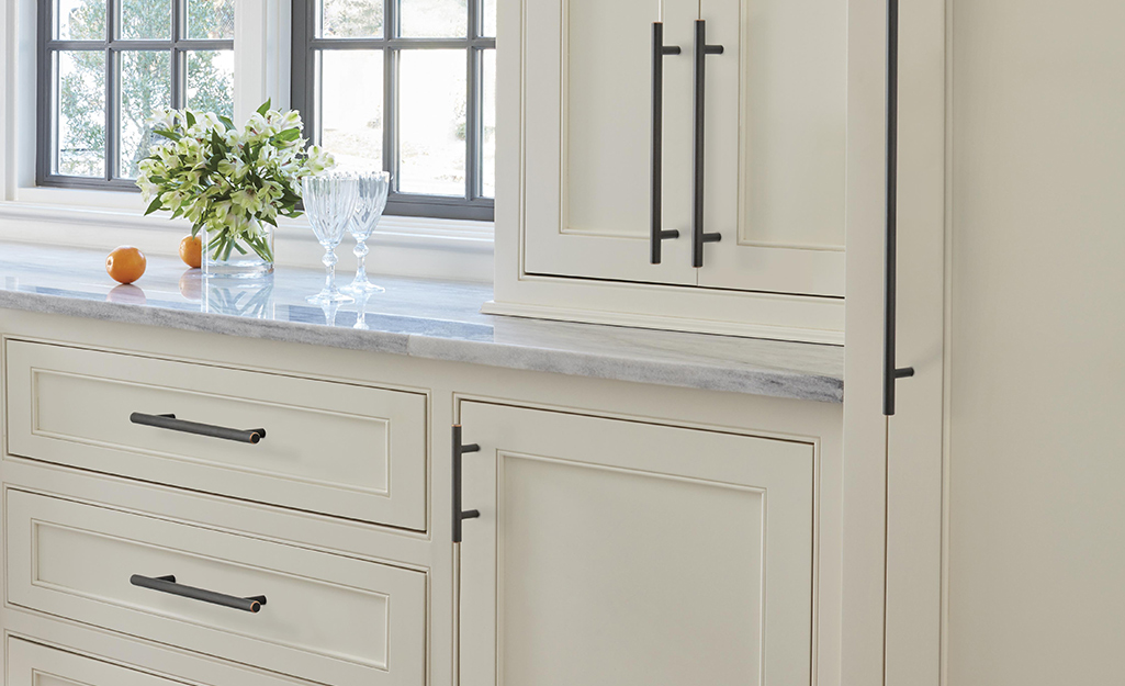 Cabinet handles with matching appliance pulls on white cabinets.