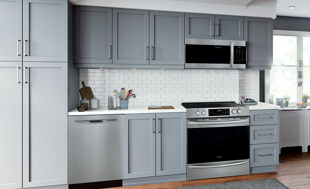 A kitchen with gray cabinets and cupboards of modern design.