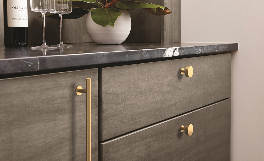 A kitchen cabinet with hardware that shows a refinished look.