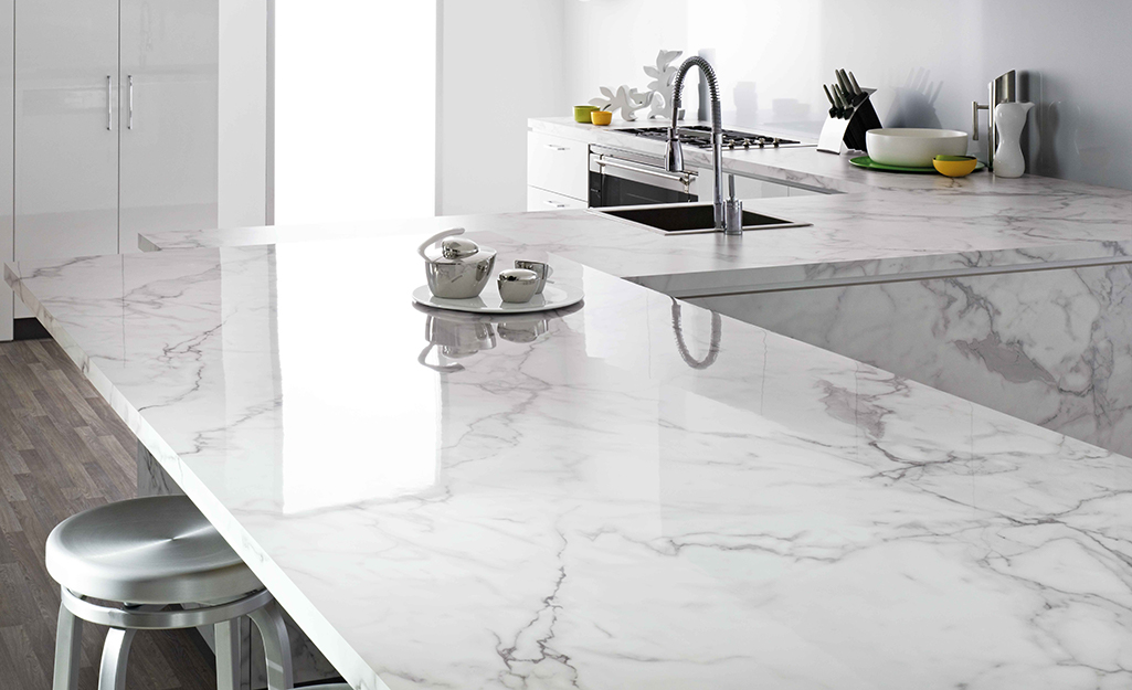 A kitchen with white marble pattern countertops.