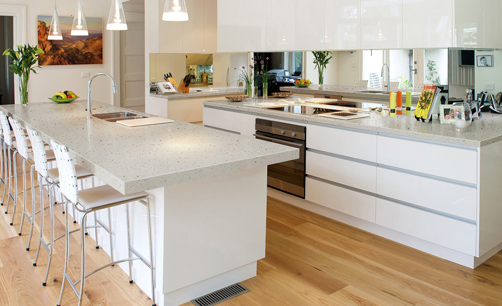 A modern kitchen with off-white solid surface countertops.
