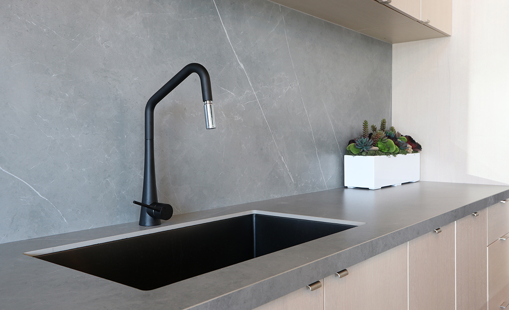 A kitchen with a gray tone porcelain countertop surface.