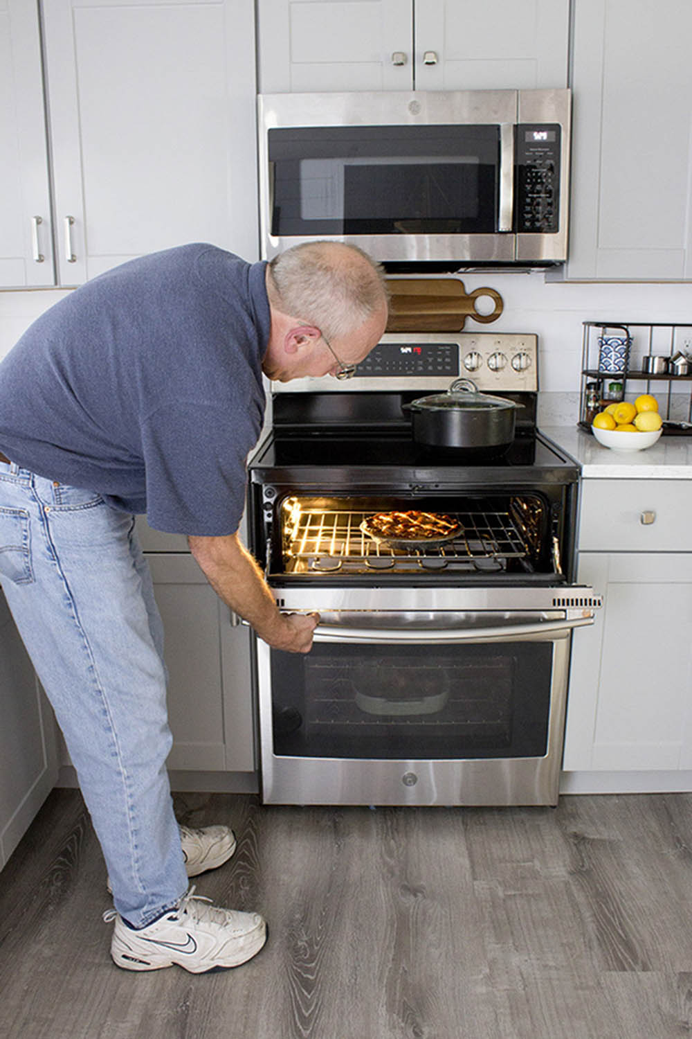 A man opens up the top oven on a double oven.