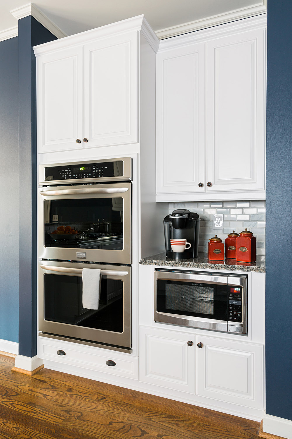 A wall with built-in double ovens and a built-in microwave.