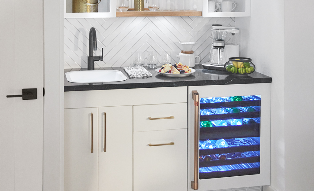 A wine fridge placed in a kitchen wet bar.