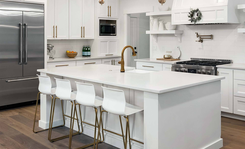 A white kitchen island placed in the center of a kitchen.