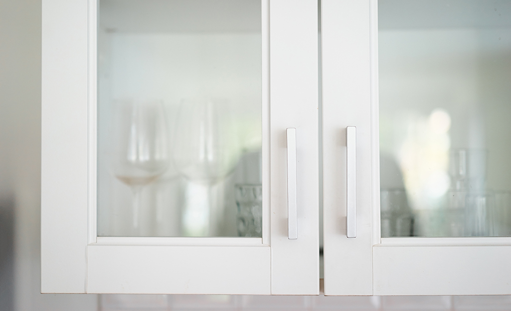 Two kitchen cabinet doors featuring glass inserts.