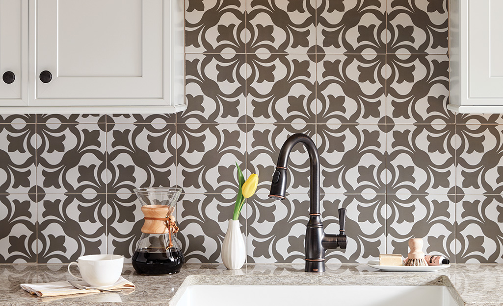 A patterned backsplash installed behind a kitchen sink.