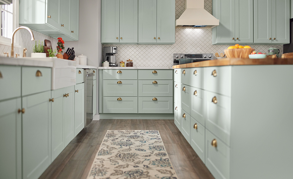 Green cabinets and island installed in a kitchen.