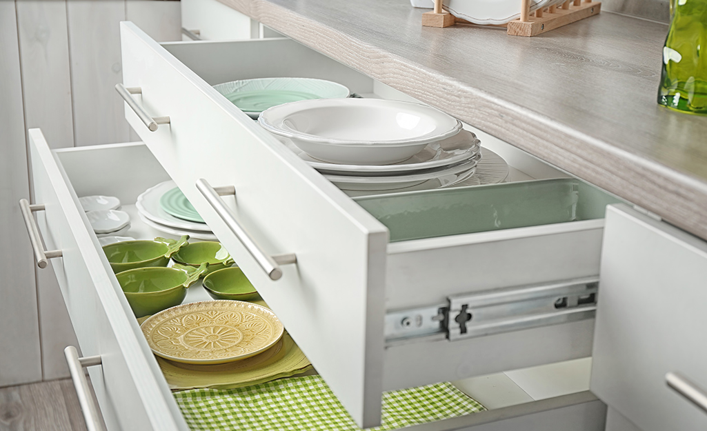 Dinnerware organized neatly in a cabinet drawer.