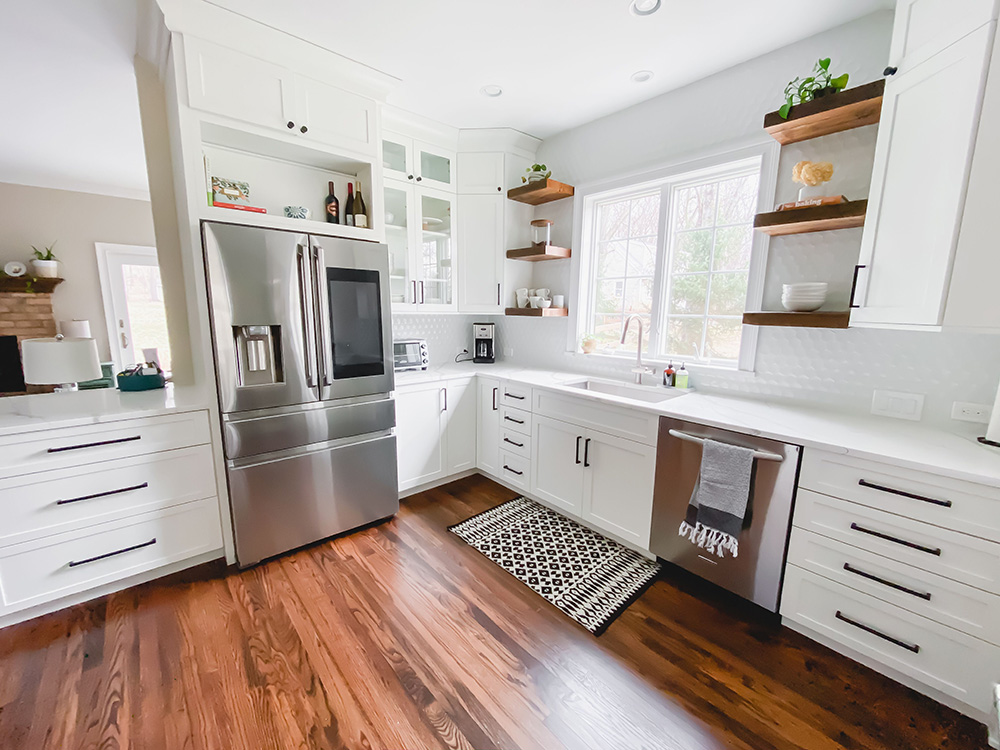 An updated kitchen with white cabinets and open shelving.