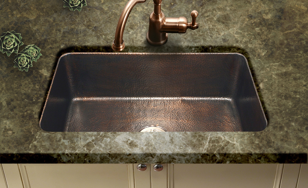 A copper single bowl kitchen sink.