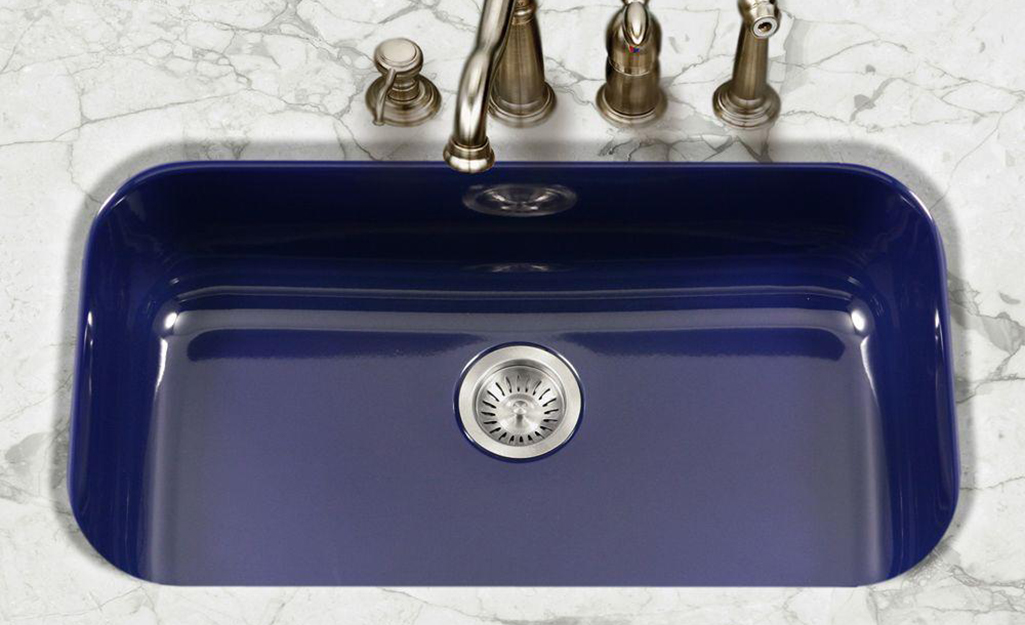 A blue single bowl sink with four tappings for a faucet, sprayer and soap dispenser. A blue single bowl sink with four tappings for a faucet, sprayer and soap dispenser.