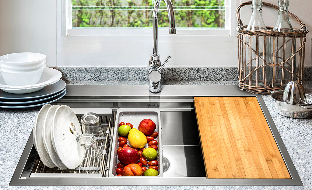 Dishes and produce in a kitchen sink.