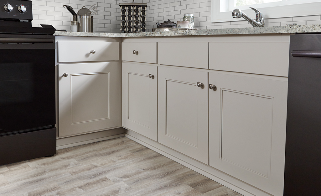 A bright and airy kitchen with white refaced cabinets.