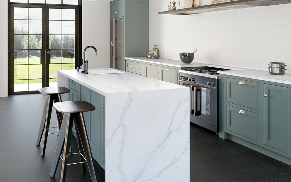 A modern kitchen with a marble waterfall counter kitchen island and gray cabinets.