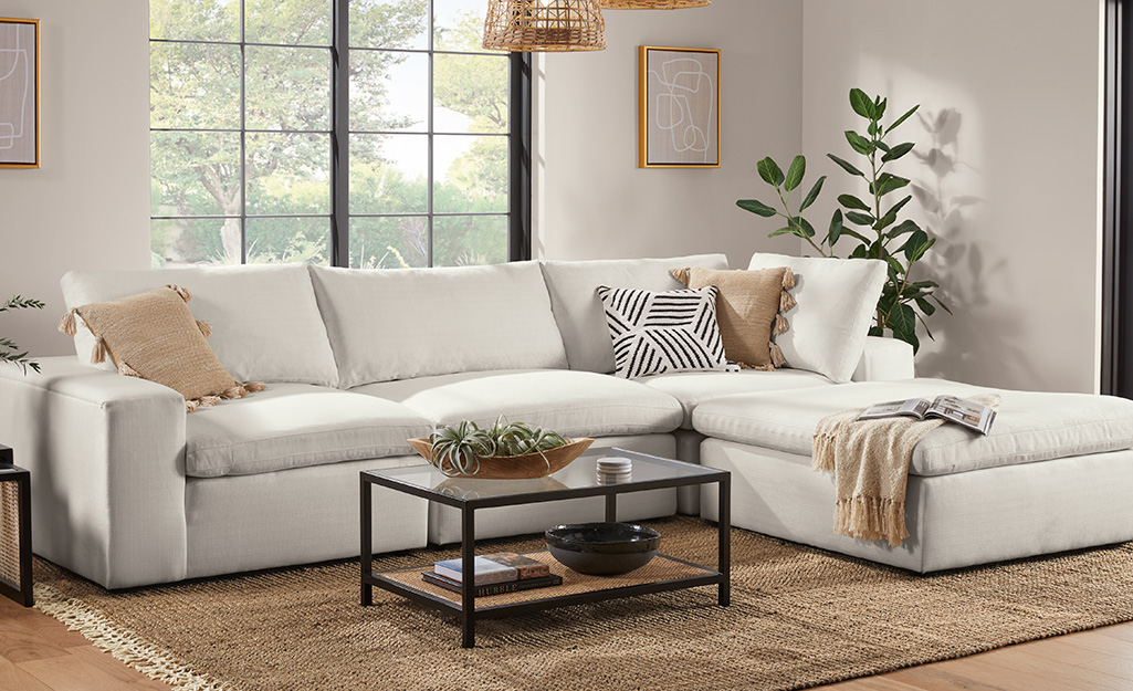 A living room with white sofa and neutral throw pillows.