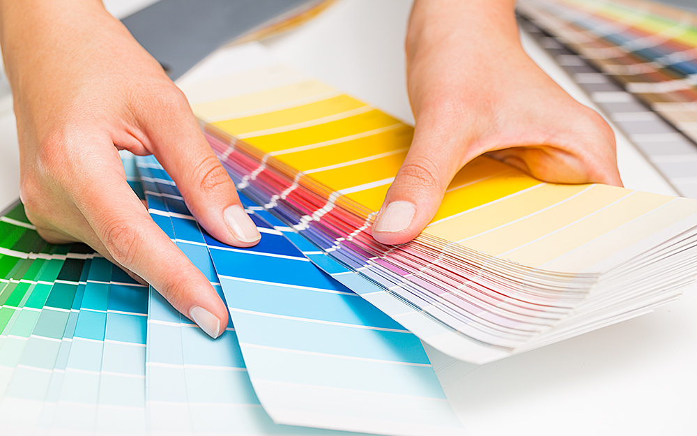 A person looking through a paint chip fan deck.